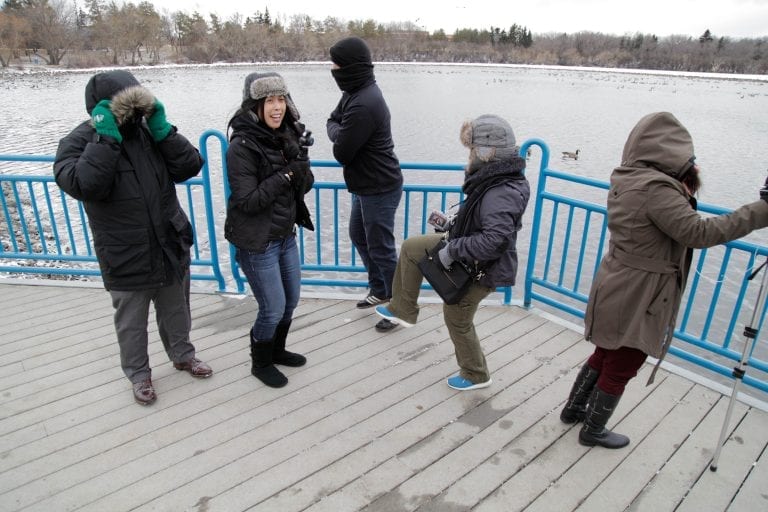 Production crew in outer winter wear jumping around outside trying to stay warm.