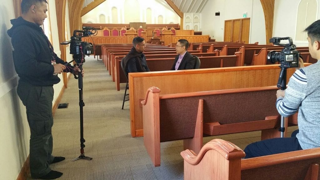 Behind the scenes of camera crew with Nan Zapanta interviewing Edwin Malang inside the sanctuary of the house of worship.