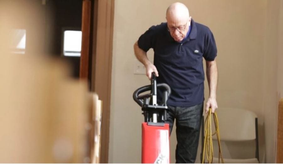 Man vacuuming inside a the worship building