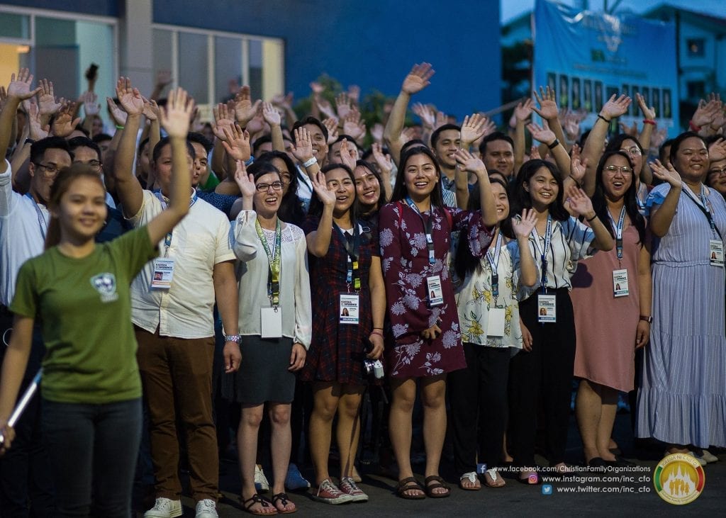 group in semi-formal clothing waving
