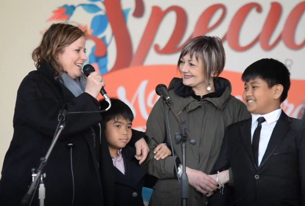 Two teachers with two students on stage during Teacher Appreciation Day in Rome.