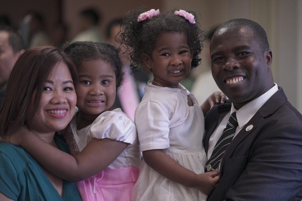 A family of 4 posing: two daughters, mother and father. 