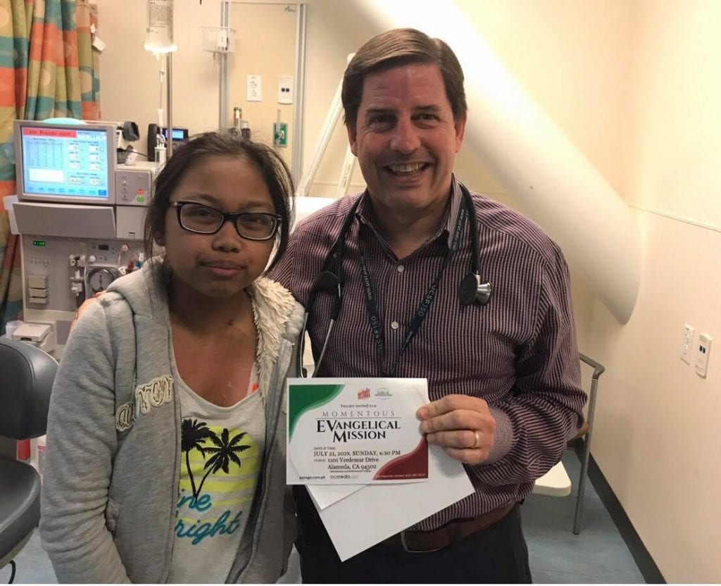 A girl and a male medical profession smiling and posing for a photo together. 