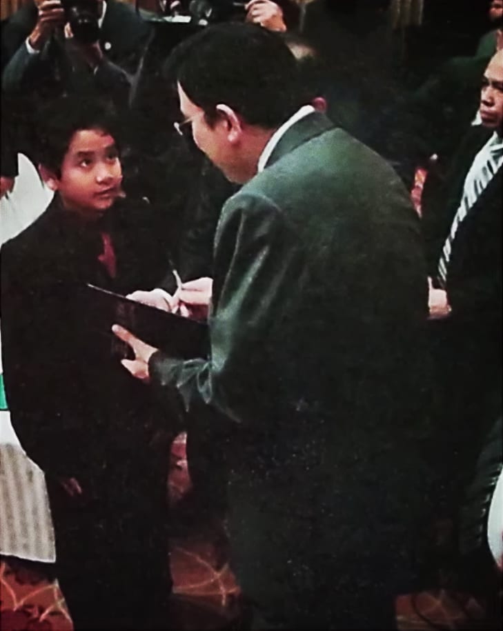 A boy getting an autograph from the Executive Minister. 
