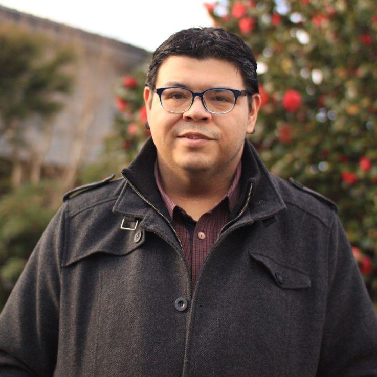Man with glasses smiling into the camera