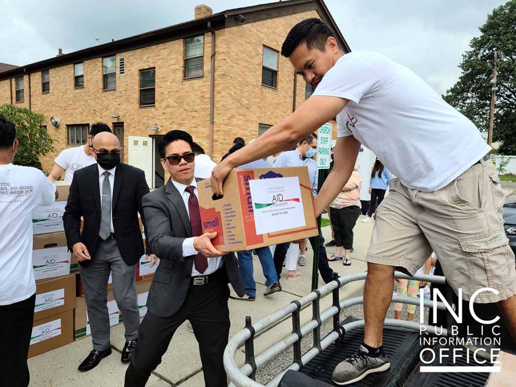 A donated box of canned and dry food items being unloaded by members of the Iglesia Ni Cristo.