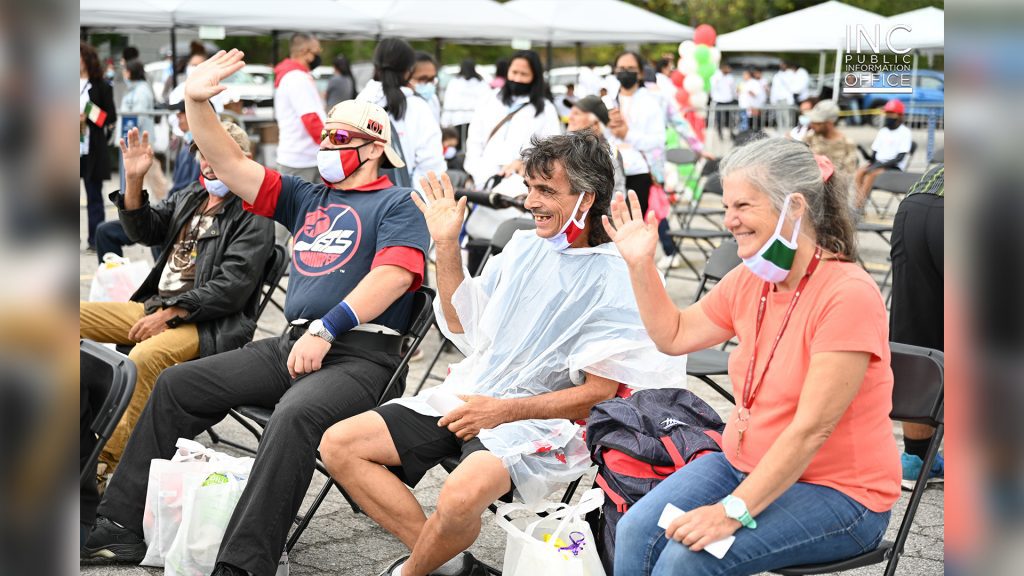 Gatineau residents and recipients of free care packages from the FYM Foundation wave and smile at Aid To Humanity event.