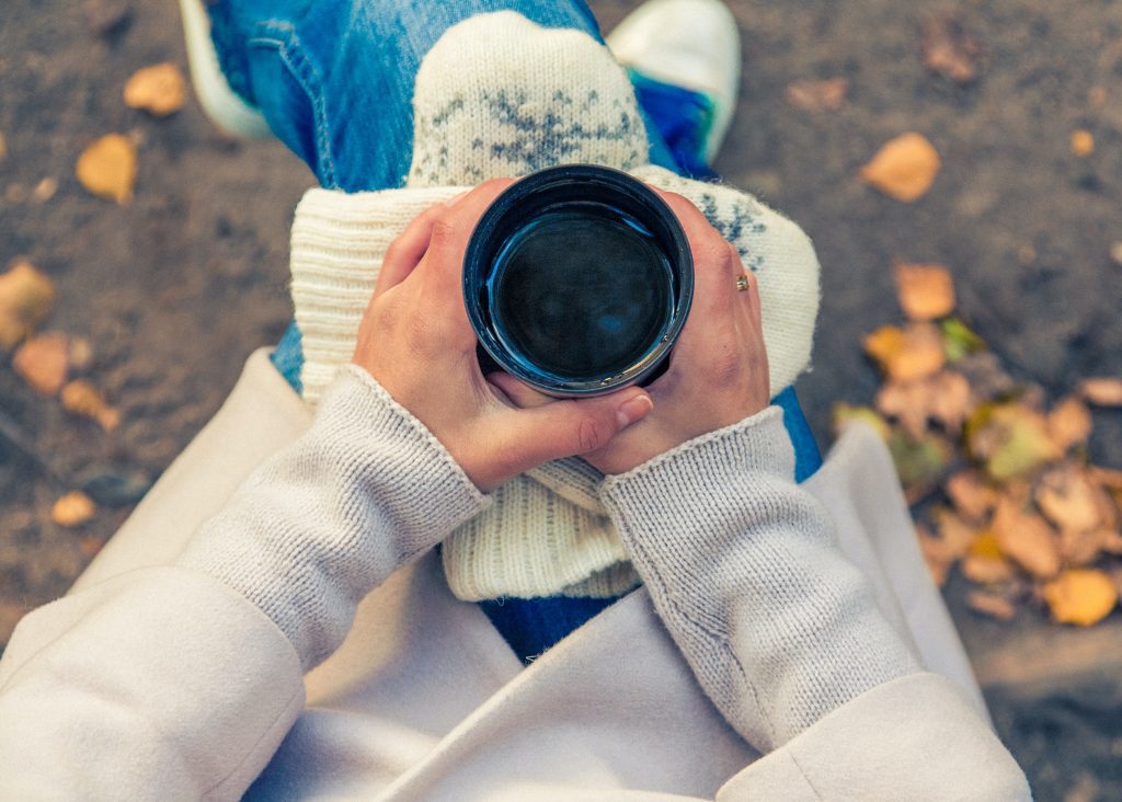 girl holding cup of coffee