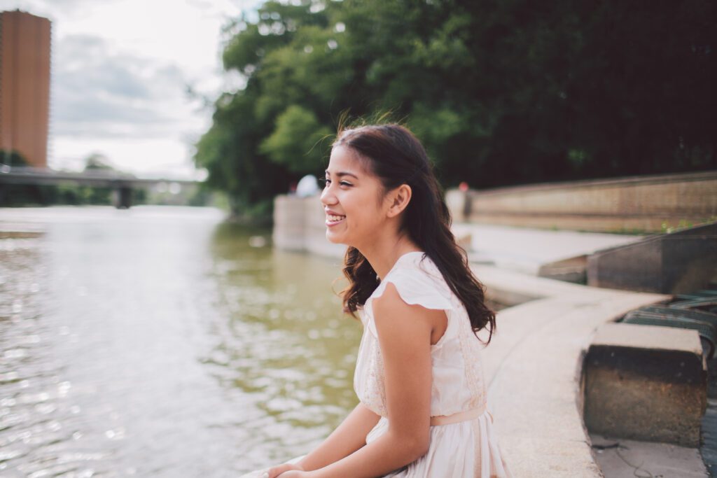 girl by the water smiling
