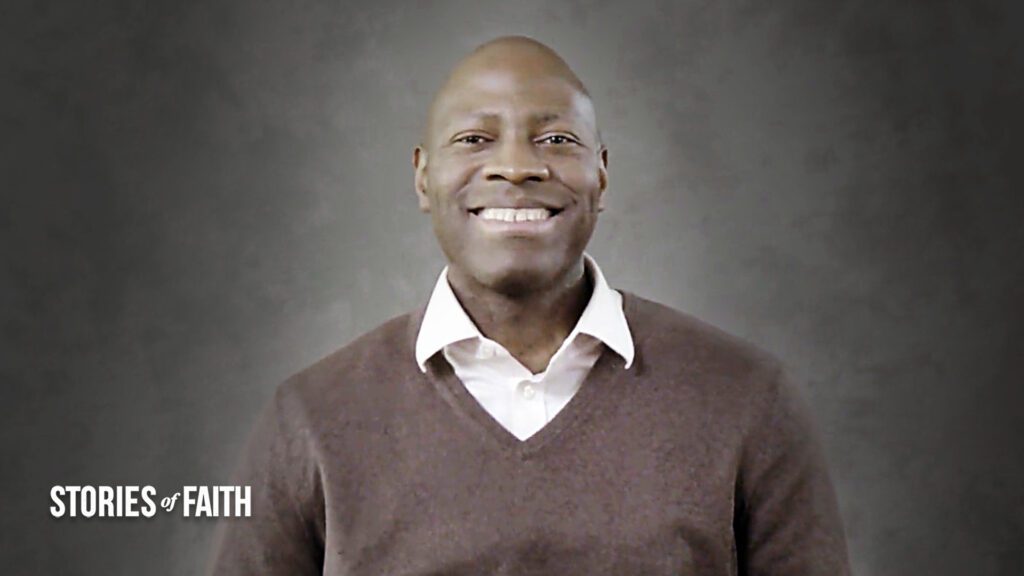 man smiling in front of a backdrop