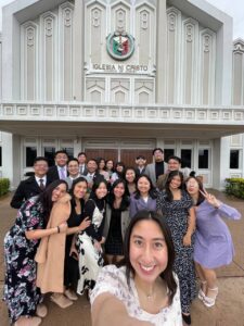group of friends in front of a church of christ worship building